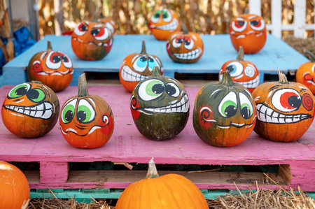 Painted pumpkins with cartoon faces on colorful pallets.の写真素材
