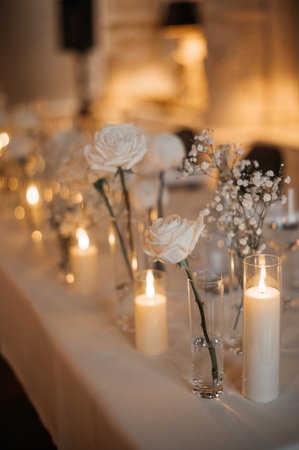 Elegant wedding table setting with white roses and candles.の写真素材