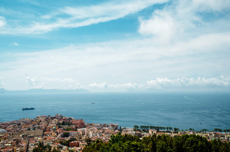Coastal cityscape with ocean and cloudy sky