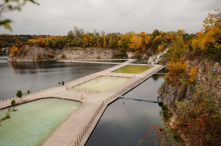 A scenic view of a quarry lake with wooden walkways and autumn foliage.