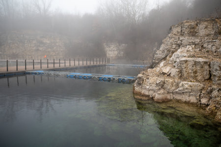 Foggy quarry with a calm water surface and rocky cliffs. Zakrzowek, Krakowの写真素材