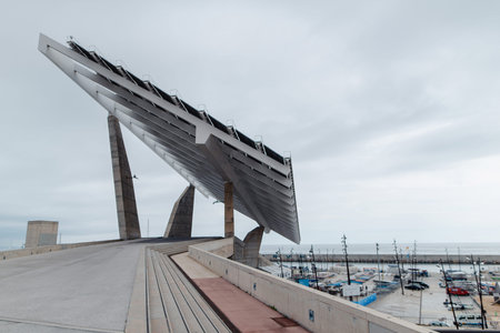 A striking modern solar energy installation stands prominently near a bustling harbor filled with...