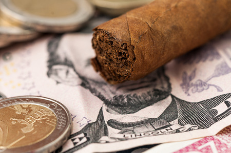 Money five Dollar Bill, Cuban cigar, one and two Euro Coinsの写真素材