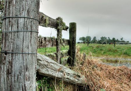 A broken wooden fence on farmlandの写真素材