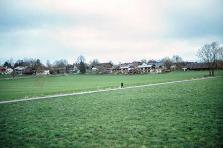 Grass and buildings under blue sky and white clouds