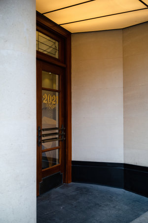The entrance to the building with a wooden door and a glass door