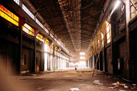 Abandoned industrial hall of an old factory in the evening.