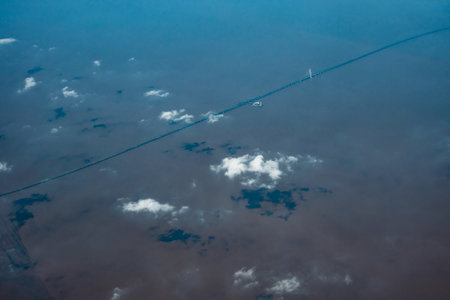 Aerial view of airplane wing with clouds in the blue sky.の写真素材
