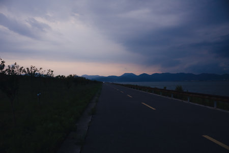 landscape of the road in the evening with beautiful clouds and mountainsの写真素材