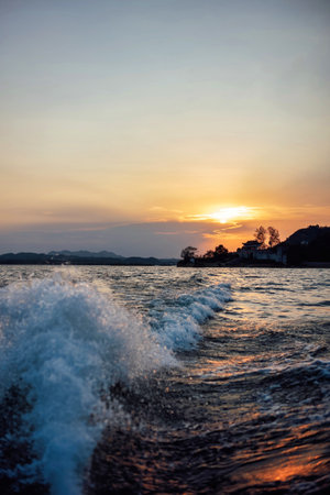 Beautiful sunset over the sea with splashes of water and foam.の写真素材