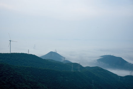Mountains and wind turbines on a foggy day, South Koreaの写真素材