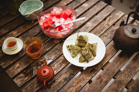 Traditional Chinese dumplings on a wooden table with teapotの写真素材