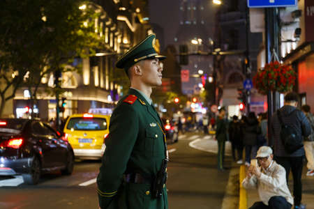 China Soldier standing in attention position in front of The Bund, Shanghai China with a curious touristのeditorial素材