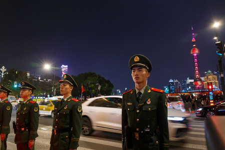 China Soldiers standing in attention position in front of The Bund, Shanghai China with Oriental Pearl TV Tower as the backdropのeditorial素材