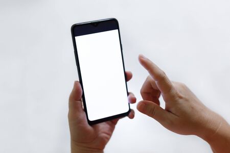 Hand pointing at a Phone with Blank Screen and white backgroundの写真素材