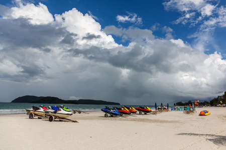Langkawi's famous Chenang beach/ Pantai Cenang with empty banana boats and water jet ski seen ashore.のeditorial素材