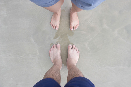 Male and female stepped foot on the sand.の写真素材