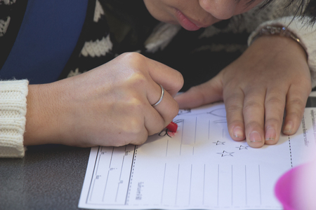 Children are drawing in paper on tableの写真素材