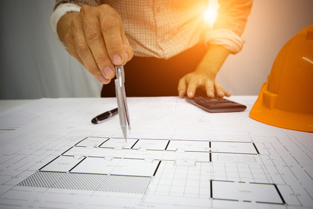 Architect Writing home project  on the desk with a blueprint in the office, Vintage, Sunset light.Selective Focus at Construction Siteの写真素材