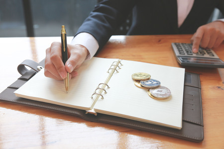 Business women are calculating the cost of running a public relations project for an organization.