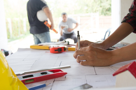 team Engineer and Architect consult projct with blueprint  at Construction Site