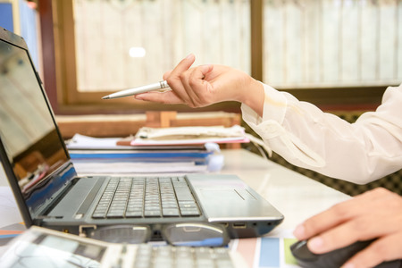businessman hands searching for data on Notebook with analyzing charts at his workplace.の写真素材