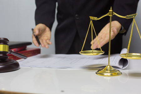 Business lawyer writing hard at office desk workplace with paper and documents.conceptの写真素材