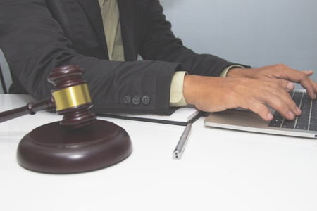 Business lawyer writing tax at office desk workplace with book and documents.の写真素材