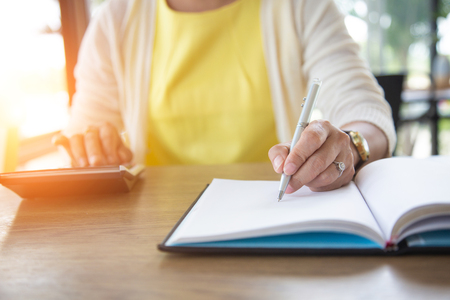 Business women using calculator for calculate tax in office.investments conceptの写真素材