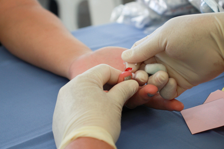 doctor is taking blood to test the blood sugar.Health care Risk groupの写真素材