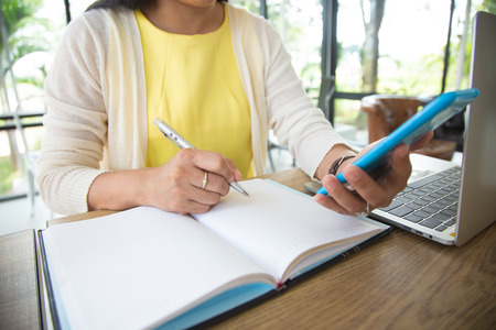 Business women are searching for information on their competitors with mobile phones to plan their...