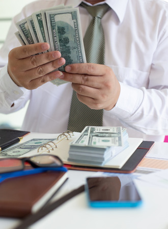 Male businessmen are counting friends' banknotes as expenses for investing in online sales.conceptの写真素材
