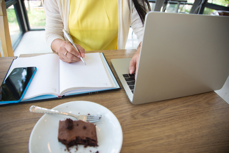 Business women are searching for information on their competitors with mobile phones to plan their future investments.conceptの写真素材