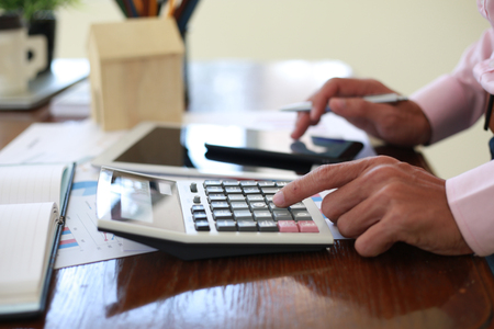 Hand man doing calculate and thinking on desk about tax at home office.の写真素材