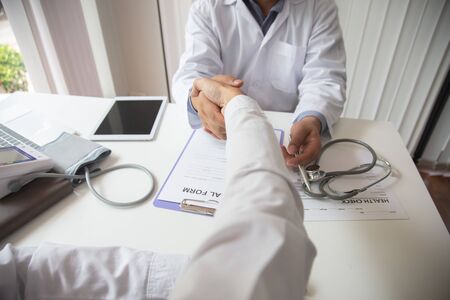Doctors are encouraging patientson doctors table in hospital. to have the power to fight off illness.の写真素材
