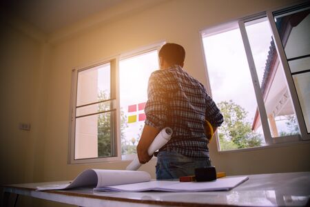 architect man handwriting with blueprint to build houses. After agreeing the employment price the cost of construction and repair real estateの写真素材