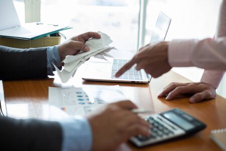 business man using calculator and holding bill for calculate tax in office.