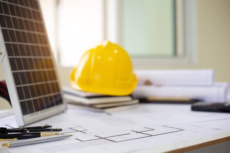Desk of Architectural working solar panel home project in construction site,With drawing equipment...