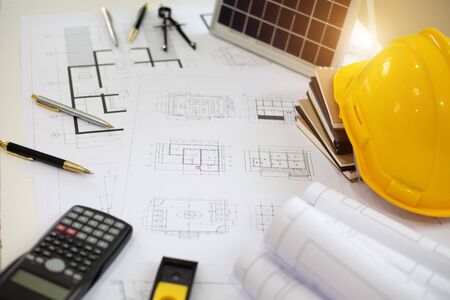 Desk of Architectural working solar panel home project in construction site,With drawing equipment...