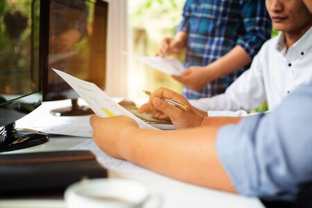 Team of programmers are discussing the use of online business investment management software in the...