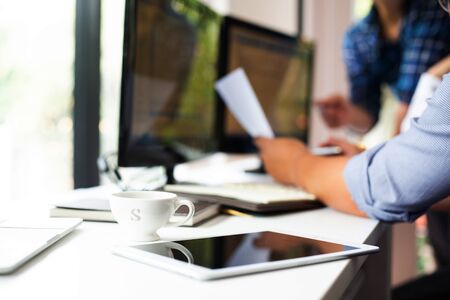 Team of programmers are discussing the use of online business investment management software in the...