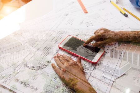 Girl playing mobile phone his father's drawing equipment.の写真素材