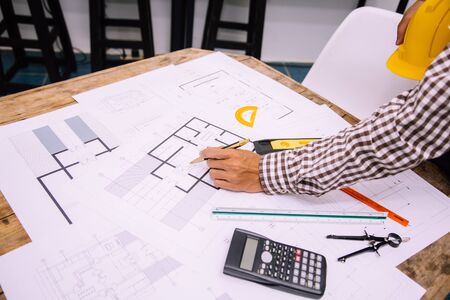 Engineer man and Architect drawings blueprint at Construction Site.Home Project to Offer Management