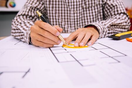 Engineer man and Architect drawings blueprint at Construction Site.Home Project to Offer Management