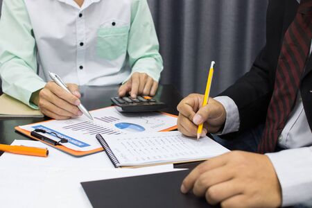 Business man Writing expense information in home office.team work conceptの写真素材