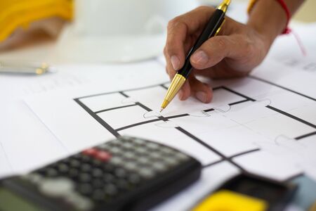 architect man handwriting with blueprint to build houses. After agreeing the employment price the...