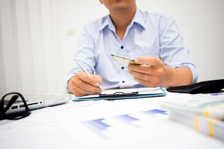 businessman using calculator and holding money for calculate tax in office.