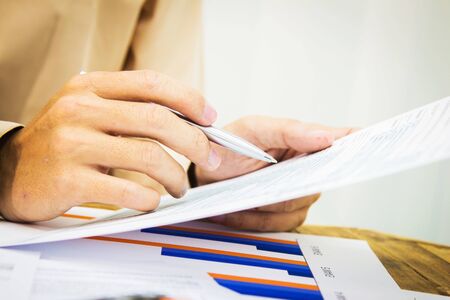 Hand man Writing tax on desk about atの写真素材
