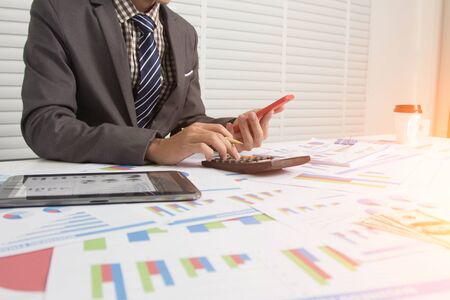 Business man using calculator and holding pen for calculate tax in office