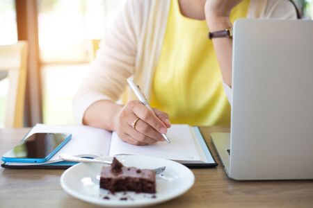 Business women are searching for information on their competitors with mobile phones to plan their future investments.conceptの写真素材